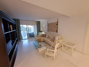 Luxury Apartment in Playas del Duque , Puerto Banus by Holidays & Home في مربلة: غرفة معيشة مع أريكة وتلفزيون