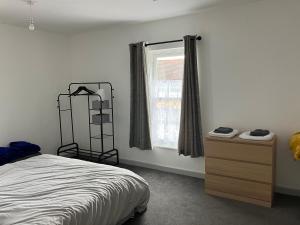- une chambre avec un lit, une commode et une fenêtre dans l'établissement Lancing Apartments 2 Bedrooms, Sleeps 5 to 6 First floor Slough M4 Legoland, à Slough