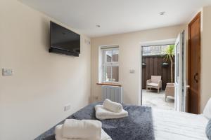 a bedroom with a bed and a tv on the wall at The Barn in St Just