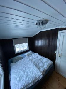 una camera con un letto in una piccola stanza di Høstkos og ro på Budor, 4 roms hytte med peis og wifi a Nordset