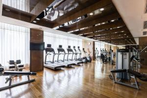 a gym with a row of treadmills and machines at Ramada Plaza Liuzhou Liudong in Liuzhou