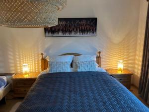 ein Schlafzimmer mit einem blauen Bett und zwei Nachttischen in der Unterkunft Happiness at Lili in Verviers