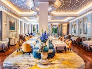 een restaurant met tafels en stoelen in een kamer bij Sofitel Legend Metropole Hanoi in Hanoi