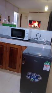 uma cozinha com um micro-ondas e uma caixa num balcão em Carley's comfort home em Thika