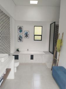 uma casa de banho com uma banheira, um WC e um lavatório. em Habitación en casa Rural Campestre em La Vega