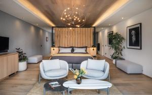 een slaapkamer met een bed en 2 stoelen bij Clouds Estate in Stellenbosch