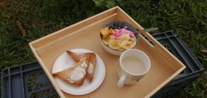 un vassoio con un piatto di prodotti per la colazione e un cesto di frutta di Habitación en casa Rural Campestre a La Vega
