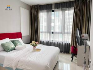 - une chambre avec un lit orné d'un vase de fleurs dans l'établissement I Soho Studio at I City by Bai Yi # 0612, à Shah Alam