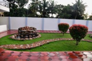 a garden with a fire pit in the grass at Spacious Guesthouse in Nagercoil in Nāgercoil