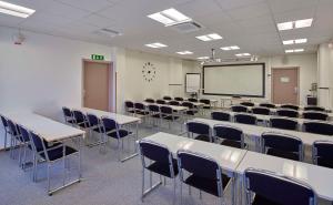 an empty classroom with tables and chairs and a whiteboard at Scandic Växjö in Växjö