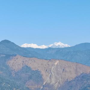 een berg met besneeuwde bergen op de achtergrond bij Hotel Mountain View in Kalimpong