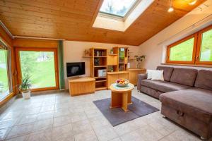 a living room with a couch and a tv at Berggasthof Lahnerhof in Liesing