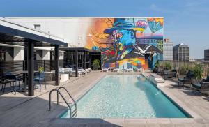 a mural on the side of a building with a pool at Hilton Shreveport in Shreveport