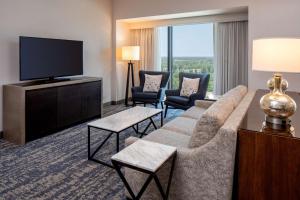 a living room with a couch and a flat screen tv at Hilton Shreveport in Shreveport