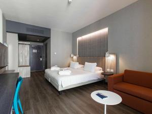 um quarto de hotel com uma cama e um sofá em Mercure Firenze Centro em Florença