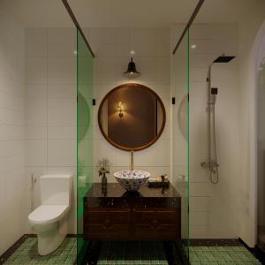 a bathroom with a sink and a toilet and a mirror at La Belle Maison in Hanoi