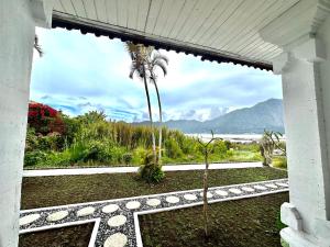 a view of the ocean from a house with a palm tree at Gill Lake Batur in Kubupenlokan