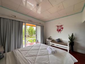 a bedroom with a white bed and a large window at Gill Lake Batur in Kubupenlokan