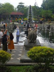 grupa ludzi stojących wokół fontanny w ogrodzie w obiekcie Wahwik's House w mieście Ubud