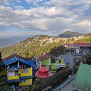 een groep huizen met bergen op de achtergrond bij Hotel Mountain View in Kalimpong