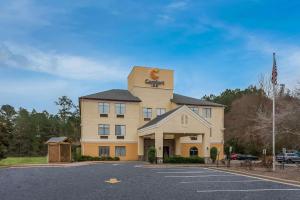 un hotel en un estacionamiento con bandera en Comfort Inn Fayetteville I-95, en Fayetteville