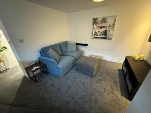 a living room with a blue couch and a table at modern 1 bed apartment with car parking in Bitton