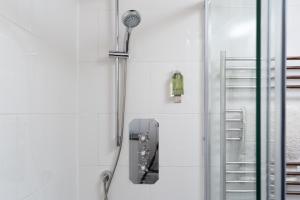a shower in a white bathroom with a shower at The Barn in St Just