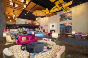 a large lobby with a pink couch and chairs at Aloft Bengaluru Outer Ring Road in Bangalore
