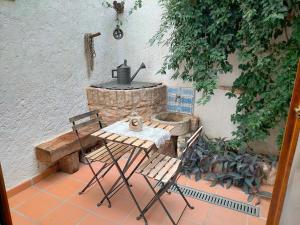 patio con mesa, sillas y parrilla de piedra en Albaga, en Sant Jordi