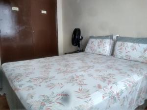 a bedroom with a bed with a flowered comforter at Apartamento Várzea in Teresópolis
