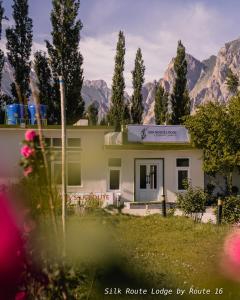 a house with mountains in the background at Silk Route Lodge in Gulmit