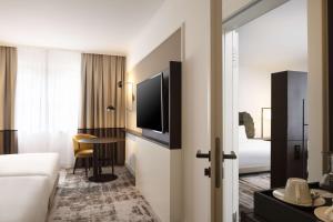 a hotel room with a bed and a television at Hilton Heidelberg in Heidelberg