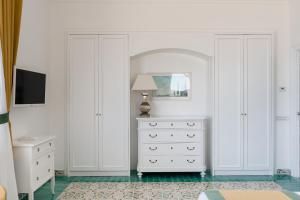 1 dormitorio con armarios blancos y cómoda blanca en Villa Eliana, en Sorrento