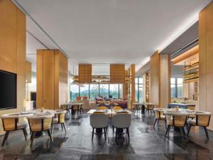 - un restaurant avec des tables et des chaises dans une salle dans l'établissement Hilton Nanjing Niushoushan, à Nankin