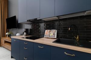 a kitchen with a sink and a black brick wall at EASY RENT- ART DECO PREMIUM Spokojna 10, Centrum, 24h Check-in in Lublin