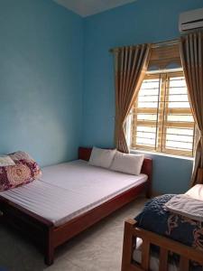 um quarto com uma cama e uma janela em Hải Phận Homestay em Ha Giang