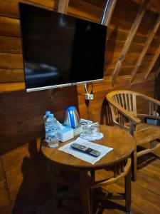 uma mesa de madeira com uma televisão na parede em Luxury Wooden House 