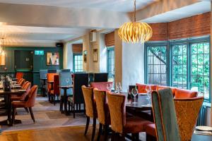 a restaurant with tables and chairs and a chandelier at The Oatlands Chaser by Innkeeper's Collection in Weybridge