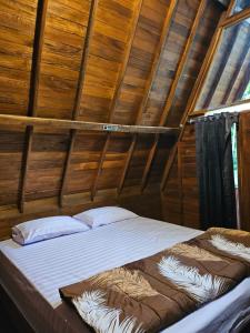 uma cama num quarto com tecto em madeira em Luxury Wooden House 
