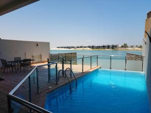 a swimming pool with a view of the water at Amwaj Resort For Families Only in Al Khobar