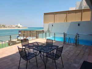 アル・コバールにあるAmwaj Resort For Families Onlyのパティオ(テーブル、椅子、水付)