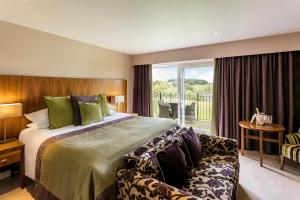 um quarto com uma cama grande e uma varanda em The Coniston Hotel Country Estate & Spa - Skipton em Gargrave