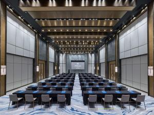 a large room with a stage with chairs and a screen at Hilton Zhuhai in Zhuhai