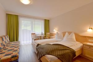 Habitación de hotel con cama y silla en Scheulinghof en Mayrhofen