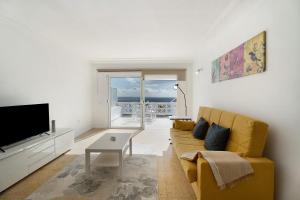 圣克鲁斯-德特内里费Apto Las Florita By Paramount Holidays的客厅里有一张黄色沙发和一台电视