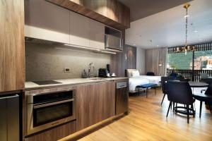 uma cozinha e sala de estar com uma cama num quarto em Salvio Parque 93 Bogota, Curio Collection by Hilton em Bogotá