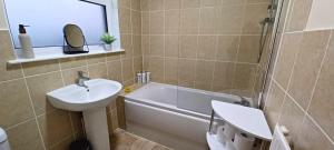 a bathroom with a sink and a tub and a toilet at Little Harries Cottage - surrounded by open fields in Ripon +28 photos
