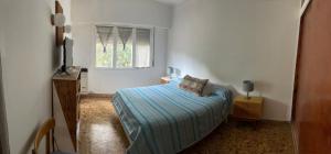 una piccola camera da letto con un letto e una finestra di Playa Quequén a Quequén