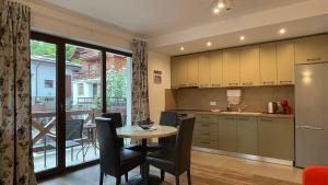 a kitchen and dining room with a table and chairs at PENTA Apartments in Sinaia