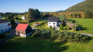 una pequeña casa con techo rojo en un campo verde en Haus auf der Insel Skuløya, en Ålesund